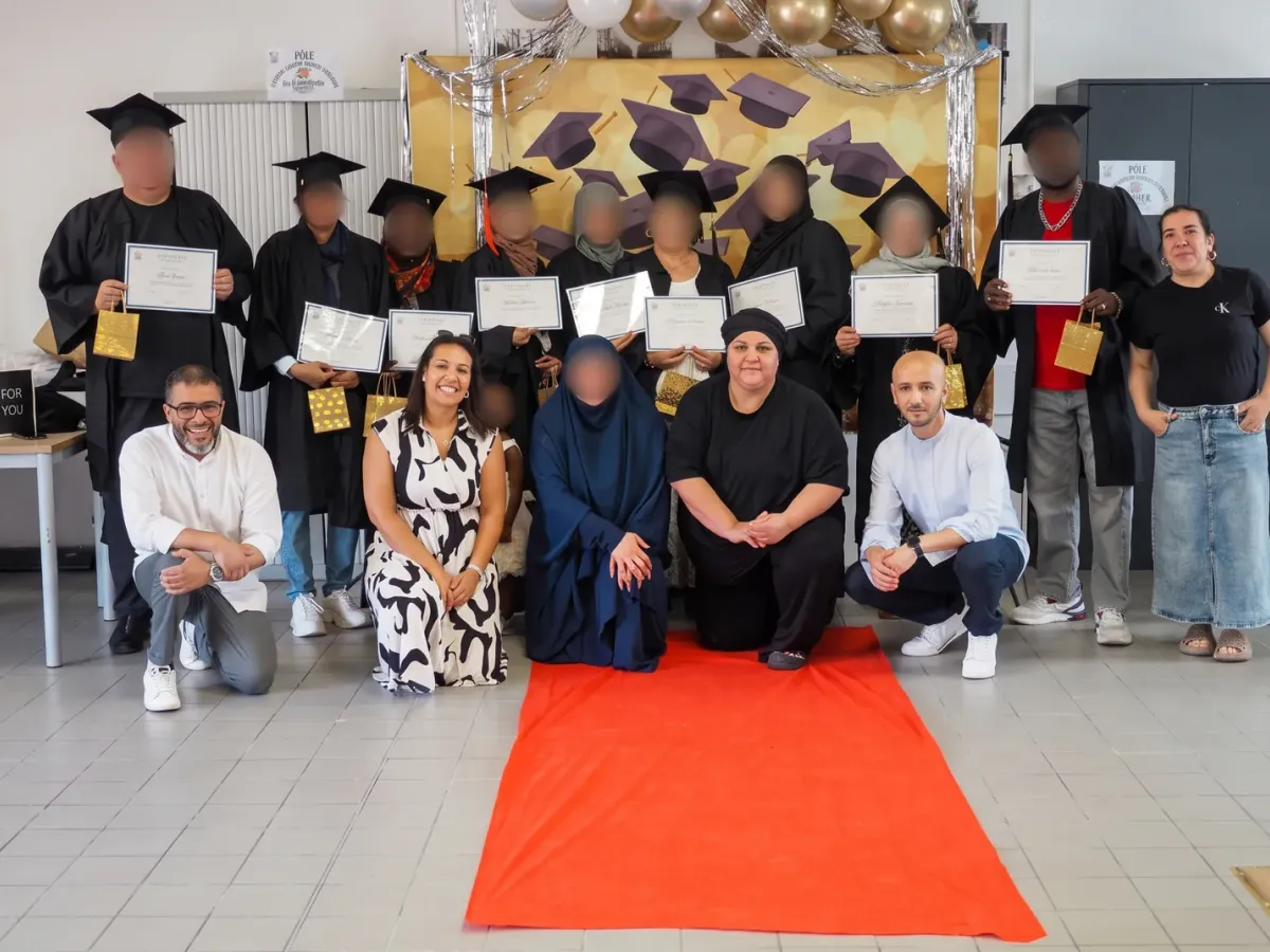 Les participants des cours de français posent avec leurs diplômes et l’équipe du pôle.