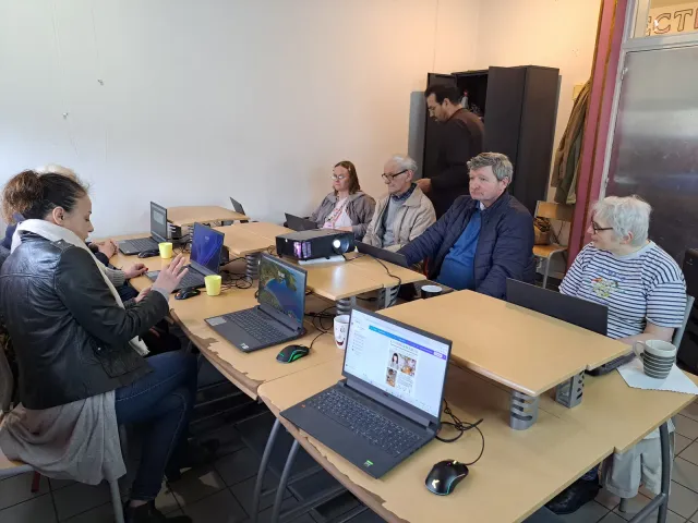 Seniors devant des ordinateurs portables pendant un atelier numérique.