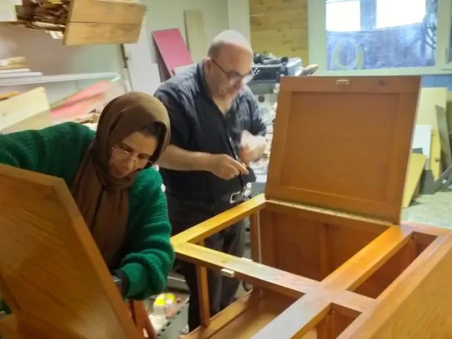 Une participante et un animateur restaurent un meuble à l’atelier Éco-brico.