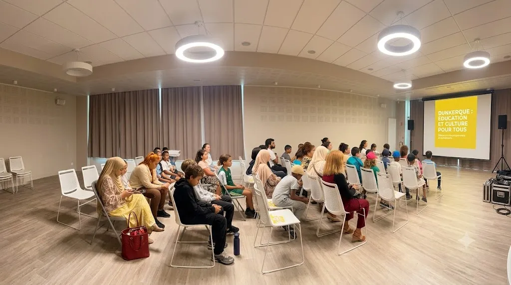 Des habitants de tous âges assis en rangs dans une salle, rassemblés pour une projection