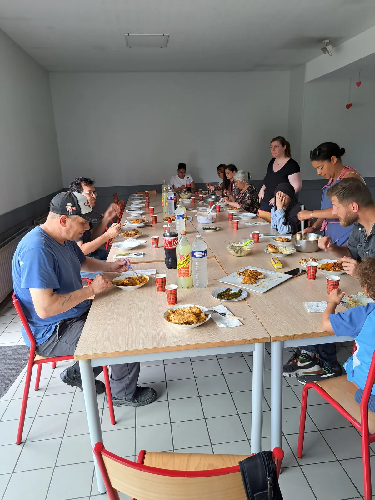 Habitants et équipe réunis autour d’une grande table pour un repas partagé au Centre