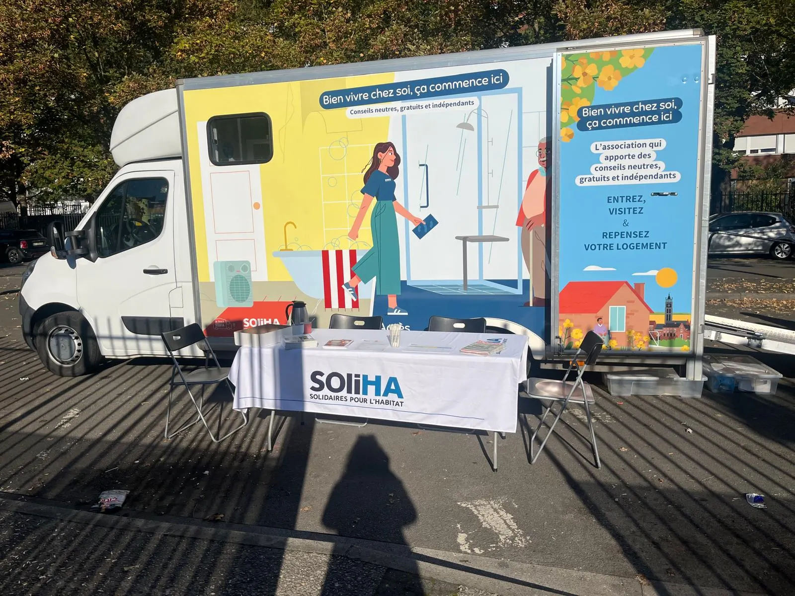Le camion aménagé de Soliha, avec son stand d’accueil, garé sur le parking du Centre