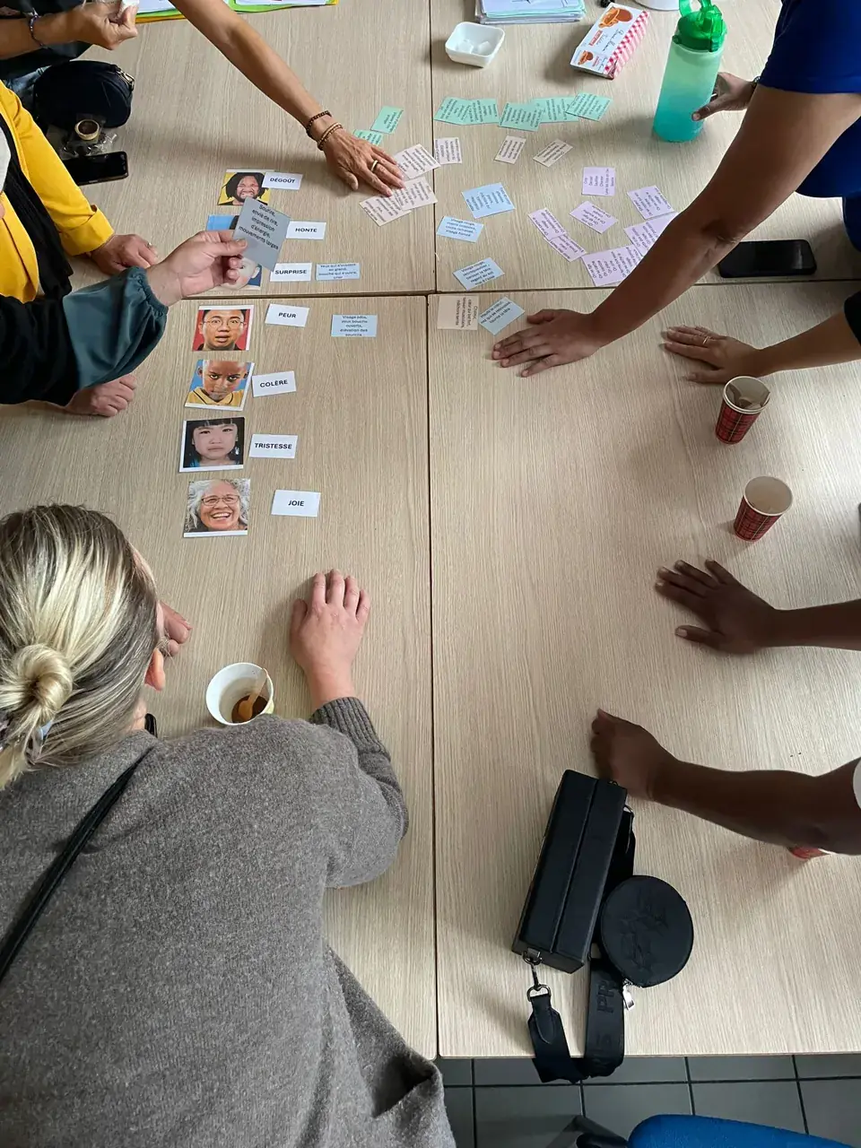 Parents autour d’un jeu de cartes sur les émotions (joie, colère, peur…) lors d’un atelier parentalité