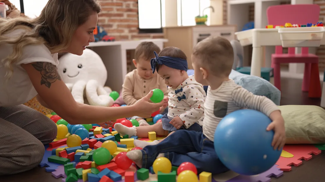Enfants et professionnelle jouant ensemble au multi-accueil de l’Hommelet